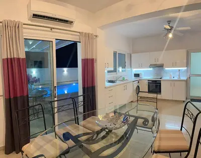 a kitchen with a glass table and chairs at Margarita Luxury 3 Bed & Pool in Dherinia