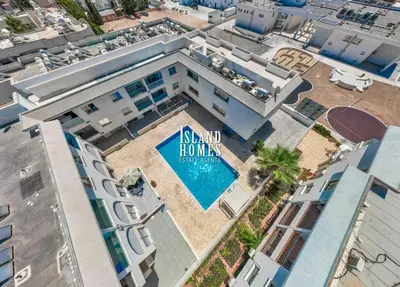 an aerial view of a building with a swimming pool at Napa blue Nissi beach apartments in Ayia Napa