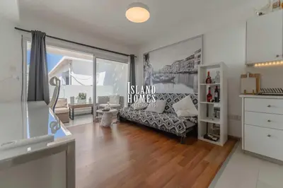a living room with a couch and a large window at Napa blue Nissi beach apartments in Ayia Napa