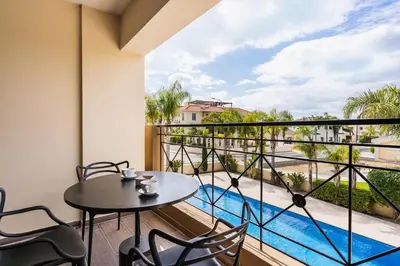 a balcony with a table and chairs and a view of a pool at 2BR Apartment with Amazing View and Pool in Kiti in Kiti