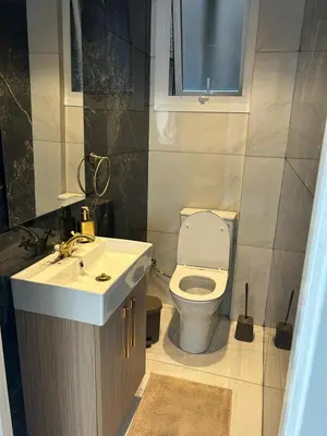 a bathroom with a white toilet and a sink at Modern 3BR Family Apartment in Quiet Drosia with Balcony in Larnaka