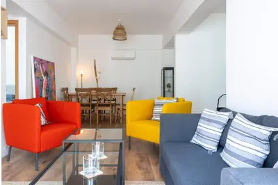 a living room with colorful chairs and a table at Stylish 2BR Apartment with Rooftop Pool in Mackenzie in Larnaka