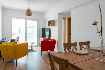a dining room and living room with a table and chairs at Stylish 2BR Apartment with Rooftop Pool in Mackenzie in Larnaka