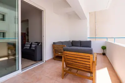 a living room with a couch and a chair at Stylish 2BR Apartment with Rooftop Pool in Mackenzie in Larnaka