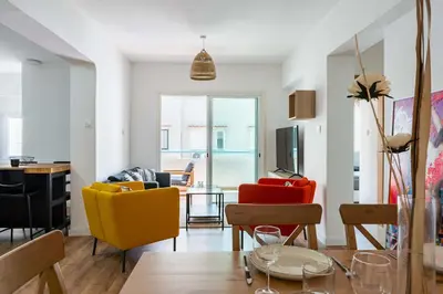 a living room with colorful chairs and a table at Stylish 2BR Apartment with Rooftop Pool in Mackenzie in Larnaka