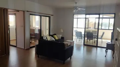 a living room with a couch and a table and chairs at Poseidon 502 penthouse in Larnaka