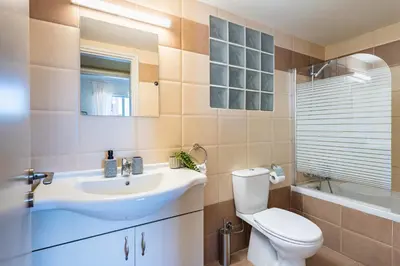 a bathroom with a toilet and a sink and a tub at Mystique 1-Bedroom Apartment in Larnaka
