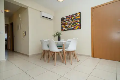 a dining room with a table and white chairs at Modern 2 bedroom flat in Engomi in Strovolos