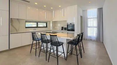 a kitchen with a island with bar stools at Aqua Beachfront Villas - Villa 1 in Ayia Napa