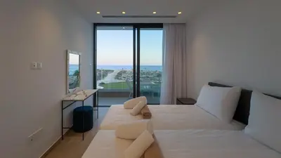 a bedroom with two beds and a view of the ocean at Aqua Beachfront Villas - Villa 2 in Ayia Napa