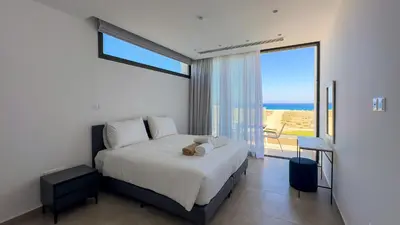 a bedroom with a bed with a view of the ocean at Aqua Beachfront Villas - Villa 2 in Ayia Napa