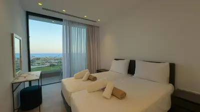 a bedroom with two beds and a large window at Aqua Beachfront Villas - Villa 2 in Ayia Napa