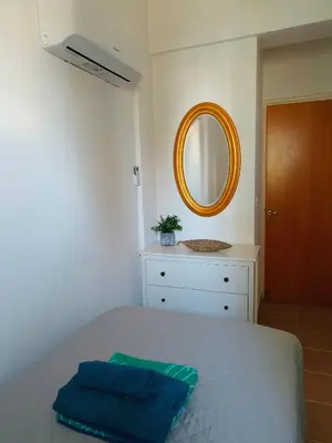 a bedroom with a bed with a mirror and a dresser at Possidon Beach Getaway in Meneou