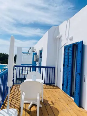 a balcony with two chairs and a table on a deck at Ikaria Village, Maisonette Sea 10 in Aglantzia
