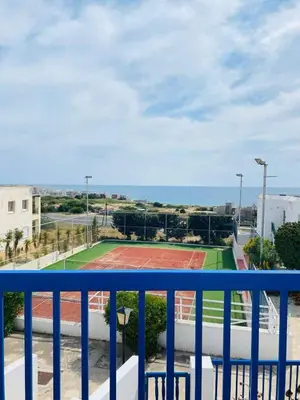 a view of a tennis court from a balcony at Ikaria Village, Maisonette Sea 10 in Aglantzia