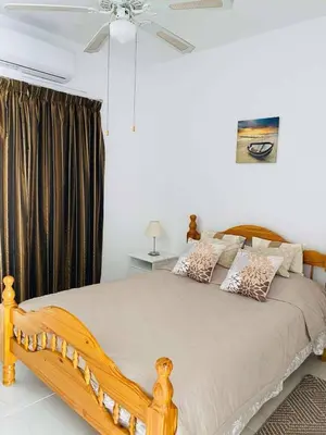 a bedroom with a wooden bed with a ceiling fan at Ikaria Village, Maisonette Sea 10 in Aglantzia