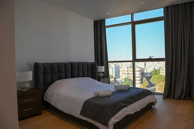 a bedroom with a large bed with a large window at The 1 -Nicosia Luxe Stay- Gym Pool 24h Concierge in Nicosia