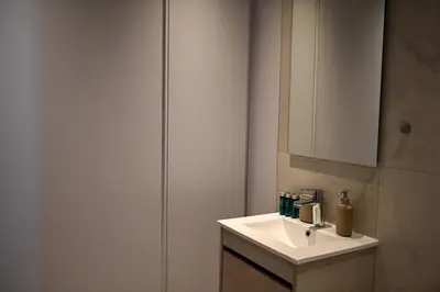 a bathroom with a white sink and a cabinet at The 1 -Nicosia Luxe Stay- Gym Pool 24h Concierge in Nicosia