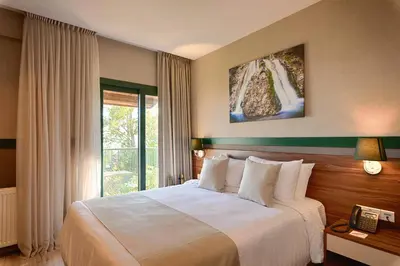 a bedroom with a large bed and a window at Petit Palais Platres Boutique Hotel in Platres