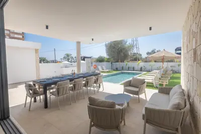 a patio with a table and chairs and a pool at Orea Luxury Villas in Ayia Napa