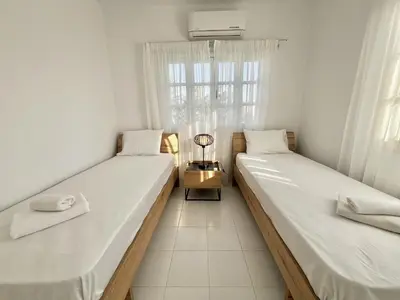 two beds in a room with a window at STAY Cavo Bay Villa in Protaras