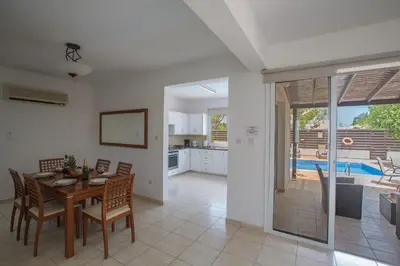 a kitchen and dining room with a table and chairs at Mandali Villa in Protaras