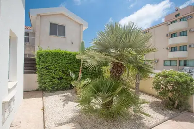 a courtyard with palm trees in front of a building at Mandali Villa in Protaras