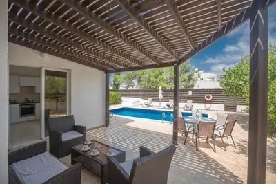 a patio with a table and chairs and a pool at Mandali Villa in Protaras