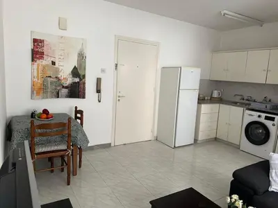 a kitchen with a refrigerator and a table in a room at Sunny house in Larnaka