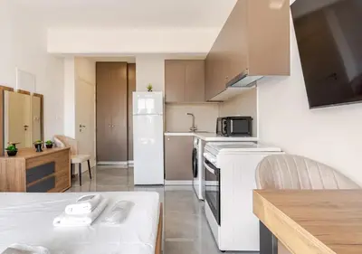 a small kitchen with a white refrigerator and a table at Urban Bay Limassol in Limassol