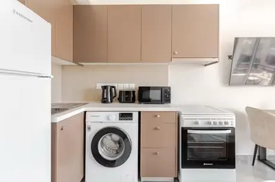 a kitchen with a washing machine and a microwave at Urban Bay Limassol in Limassol