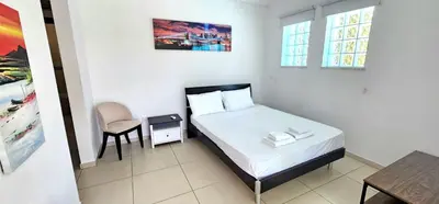 a small bedroom with a bed and a chair at Agia Thekla bungalow with pool in Ayia Napa