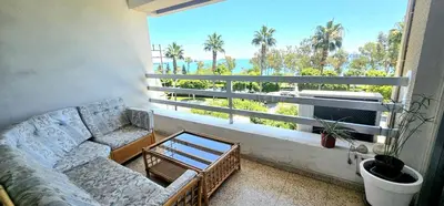 a living room with a couch and a view of the ocean at Retro art and mirrors Molos in Limassol