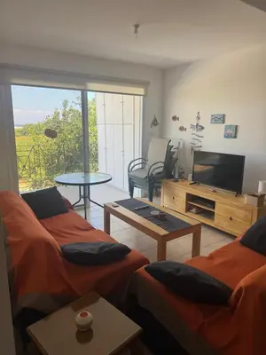 a living room with two beds and a flat screen tv at Serenity Apartment with Pool in Paralimni