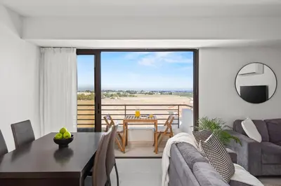 a living room with a couch and a table and a dining room at Aether Residence by Nomads in Tersephanou