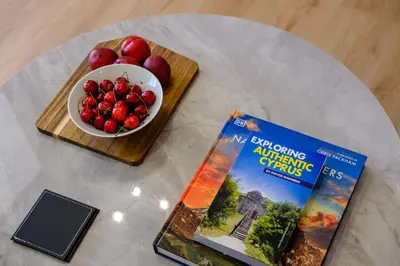 a table with a book and a bowl of fruit at Artemis 304 - Seaside Stories in Livadhia