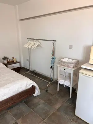 a bedroom with a bed and a desk and a table at Sandy Nest Studio in Larnaka