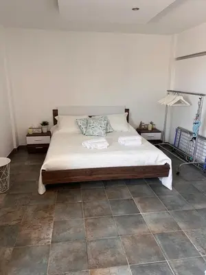 a bedroom with a bed and a tiled floor at Sandy Nest Studio in Larnaka