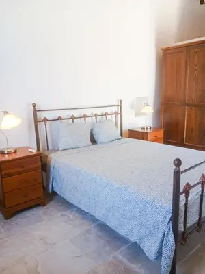 a bedroom with a bed and a dresser and two lamps at Hillside Cozy Apartment in Skarinou