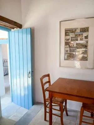 a dining room with a wooden table and a blue door at Hillside Cozy Apartment in Skarinou