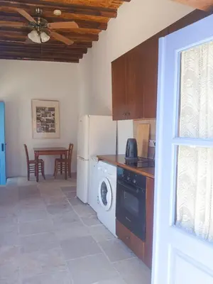 a kitchen with a washer and dryer and a table at Hillside Cozy Apartment in Skarinou
