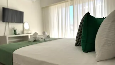 a bedroom with a large bed with green and white pillows at Modern 3BDR_Top Floor_Lux_Suite_Balcony in Limassol