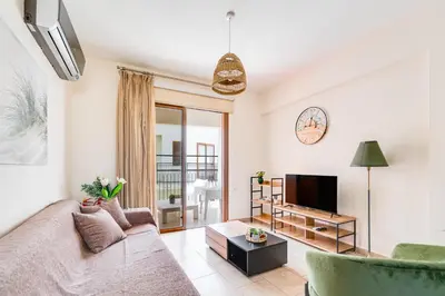 a living room with a couch and a tv at Market View Apartment - Near The Beach in Larnaka