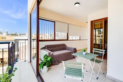 a balcony with a couch and a table at Market View Apartment - Near The Beach in Larnaka