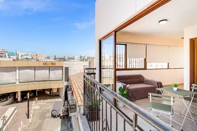 a balcony with a couch and a table at Market View Apartment - Near The Beach in Larnaka
