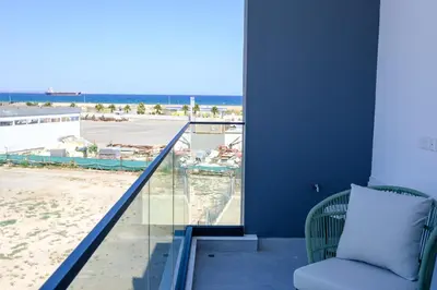 a balcony with a chair and a view of the beach at Artemis 205 - Seaside Stories in Livadhia