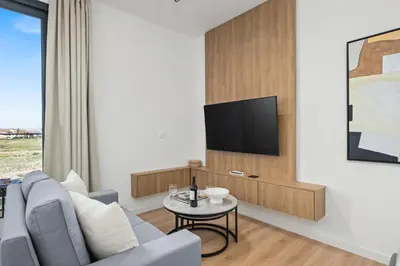 a living room with a couch and a tv at Artemis 205 - Seaside Stories in Livadhia