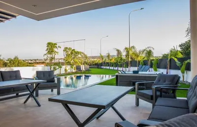 a patio with a table and chairs and a pool at Luxury Elegant Home in Protaras