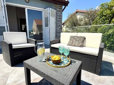 a table with a bowl of food and glasses on a patio at Elegant Beach Villa Moonstone II in Meneou