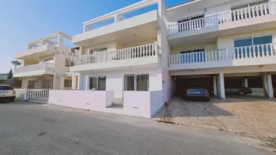 a large white building with a parking lot at Nissi 87 Apartment - Luxcyservices in Ayia Napa
